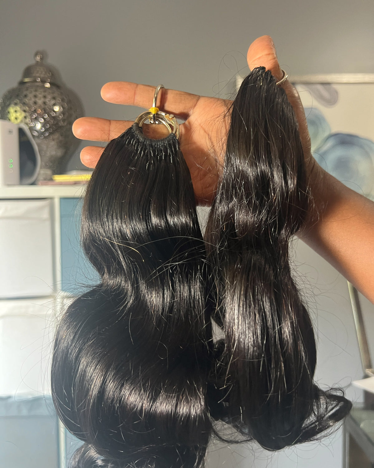 Two packs of Monroe body wave 4K Feather Crochet hair held up to show the loops and wave